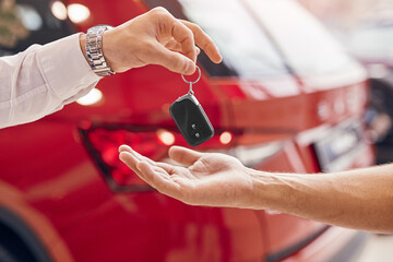 Crop customer receiving key of new car