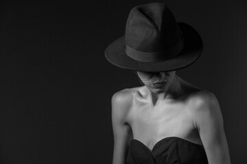 Beautiful woman portrait wearing man hat and net veil accessories, black and white fashion shot