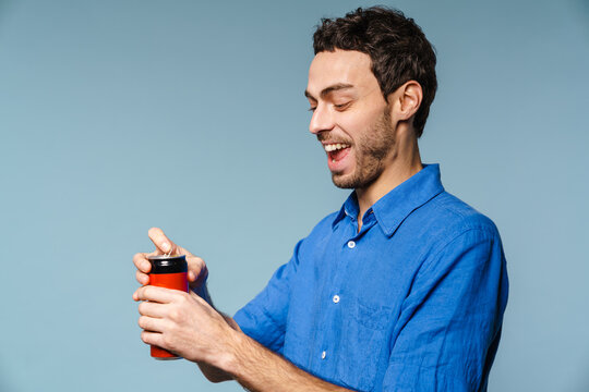 Joyful Handsome Guy Smiling While Opening Soda Can