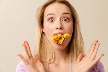 Shocked beautiful girl posing with french fries in her mouth