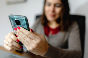 Close-up woman hands using smartphone. Girl sitting on office desk.