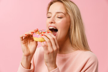 Happy charming blonde girl eating doughnut on camera