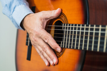 Male with his hand on the guitar strings