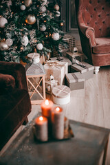 Christmas atmosphere, candles on the background of the Christmas tree and gifts