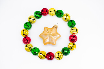 Colorful ringing Christmas bells in gold, red and green. In shape of circle with golden star christmas decoration in the middle. The concept of Christmas. Holiday background