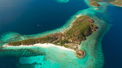 aerial view tropical island with sand white beach, palm trees. Malcapuya, Philippines, Palawan. Tropical landscape with blue lagoon, coral reef