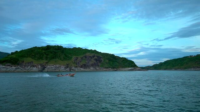 Small boat with passenger sailing accross the sea near the island