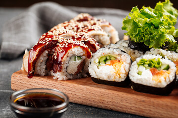 Closeup on sushi roll assorted set on the wooden board with soy sauce