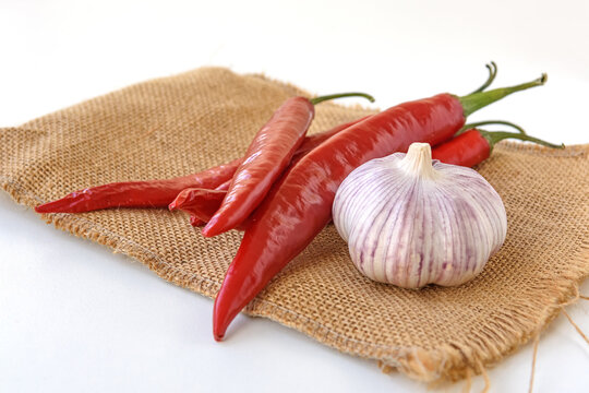 Hot red pepper and garlic on sackcloth on a white background. Close up.