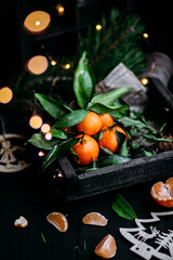 Tangerines with green leaves in a wooden box. New Year's decor