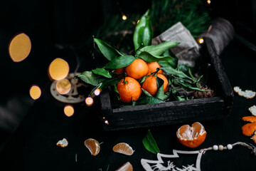 Tangerines with green leaves in a wooden box. New Year's decor
