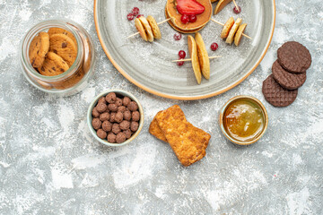 Horizontal view of buttermilk fruit pancakes with cookies biscuits and honey on blue background