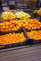 Tangerines, oranges, apples and other fruits are sold in the store. Vertical image.