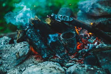 Vivid smoldered firewoods burned in fire close-up. Atmospheric warm background with orange flame of...