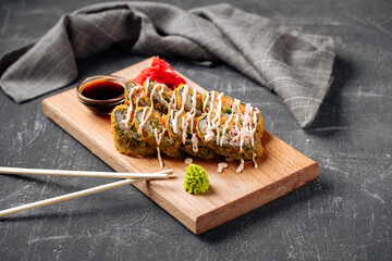 Side view on roasted tempura sushi rolls with crab and sauce © Hihitetlin