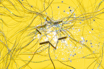 silver Christmas themed cookie cutter on a bright yellow background