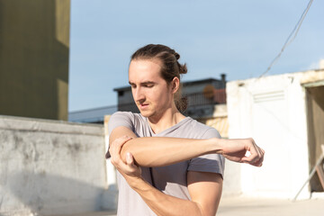 Obraz premium Man stretching his shoulder after workout.