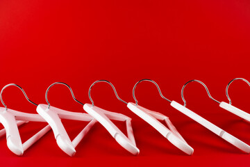 White hangers on a red background. Sales clothes concept.