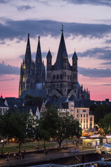 The Gothic Cathedral of Cologne in the beautiful city at sunset the details of the towers and decorations are sublime, near the river and the bridge in the background. Germany.
