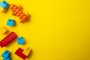 Toy blocks of different colored shapes on a yellow background.
