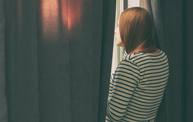 The pregnant woman standing at the window