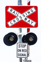 A close up vertical image of a railroad railway crossing sign post stop sign on a clean white background. See also same image but with lights on.