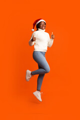 Holiday Offer. Joyful Black Santa Lady Jumping And Showing Thumb Up