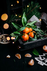 Tangerines with green leaves in a wooden box. 