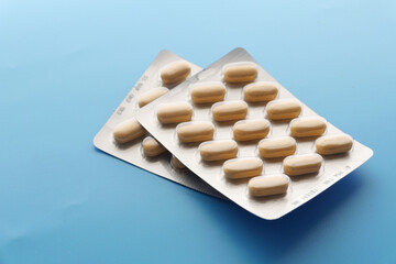 close up of pills of blister pack on blue background 