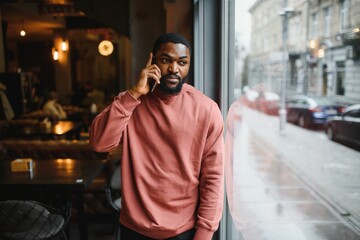 mature african american man talking by phone in cafe