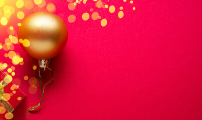 Red New Year or Christmas background and golden christmas ball on it.