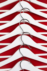 White hangers on a red background. Sales clothes concept.