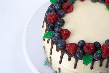 creamy cream cake with fresh berries and chocolate