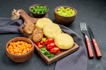 Dinner preparation for tasty cutlets chopped vegetables greens on dark background