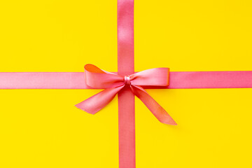 Festive pink ribbon with bow for holiday gift box or greeting card. Top view