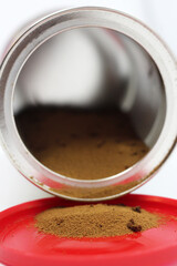 Ground coffee poured out of the jar