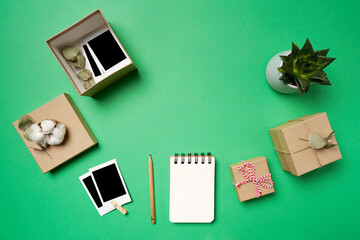Flat lay photos, photos in the box, boxes, notepad, pencil, succulents on green background. High quality photo
