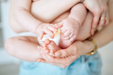 Fototapeta na wymiar little bab tiny legs and mother hands newborn