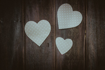 white hearts on a dark wooden background, top view