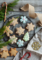Obraz na płótnie Canvas Homemade glaze sweet Christmas gingerbread and cookies at oven grill at wood background with Christmas decoration
