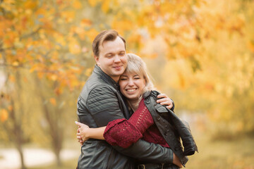 Young lovers hug and smile in the Park in autumn