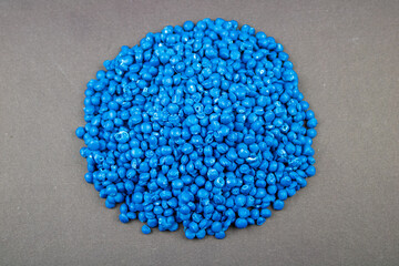Raw material plastic granules dark blue, close-up raw material brown background!