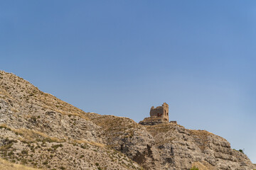 View of outer wall of stone old tower of fortress in spanish desert