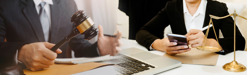 Business and lawyers discussing contract papers with brass scale on desk in office. Law, legal services, advice, justice and law concept picture with film grain effect