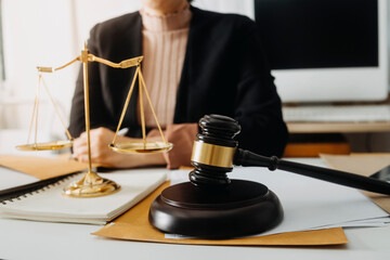 Business and lawyers discussing contract papers with brass scale on desk in office. Law, legal services, advice, justice and law concept picture with film grain effect