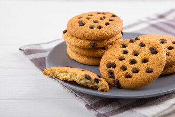 Delicious cookies with chocolate chips on a colored background