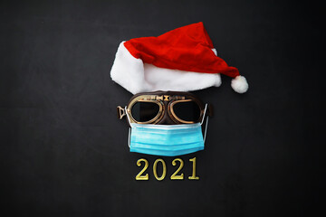 Santa Claus hat, glasses and nose with face mask on red background. Christmas or New Year celebration concept.