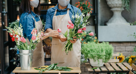 Male and female florists focused on composition in flower shop