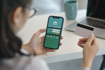 Cropped shot of a businesswoman using internet banking on a smartphone and holding a credit card.
