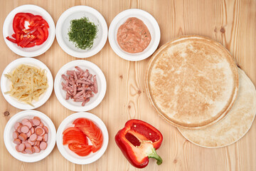 Slicing fresh food for pizza, with dough on a wooden background. Delicious homemade food.